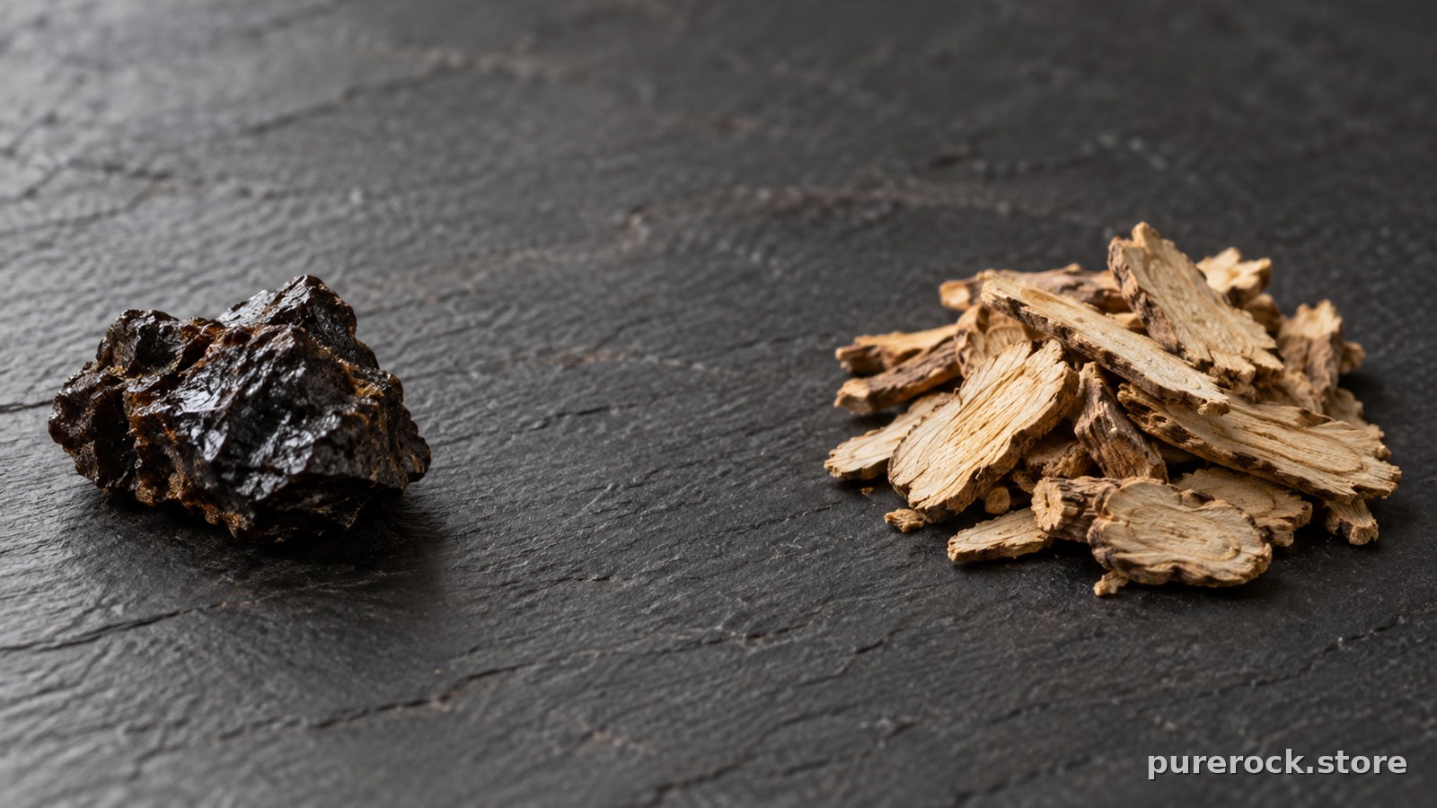 A piece of dark mineral resin beside dried, pale root slices on a stone surface, contrasting shilajit and tongkat ali